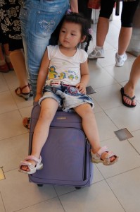 Besser als stehen: Glück für ein Kind dessen Eltern einen Trolley als Kinderwagen dabei hatten.